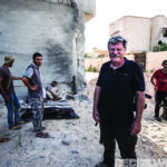 Author Robert Young Pelton, relaxing with al Bunyan Marsous militia fighters in between clearing buildings in District 3. The sea front area was the last ISIS hold out in Sirte.