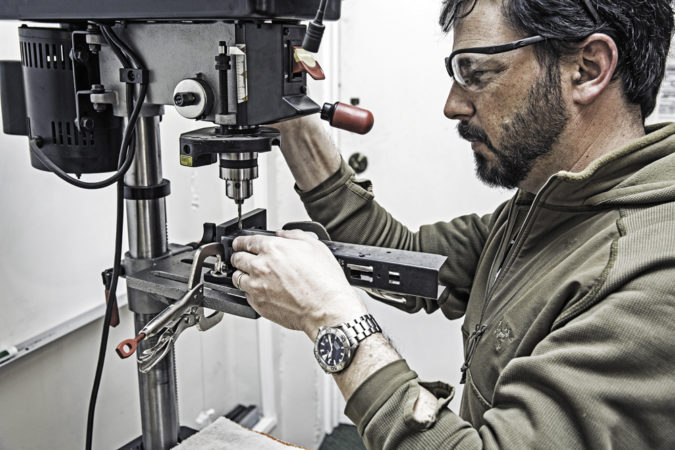 Then slide it around a drill press table to line up the holes with the drill bit, lock it down, then slide the receiver on to drill a rivet hole. Reposition the fixture for each rivet hole.