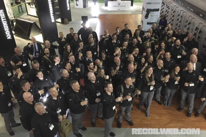 Sig Sauer Employees gather in their trade show booth at SHOT Show for the announcement that the company has been awarded the contract to supply the US Army's new Modular Handgun System.