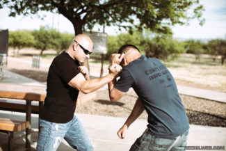 After disrupting the attacker’s balance by pulling his arm forward with his lead hand, Chad clears the attacker’s right arm with a downward hammer strike.