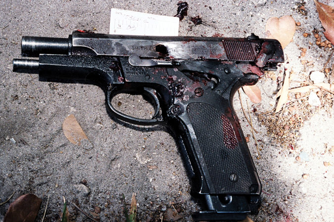 Agent Dove’s pistol, covered in blood and photographed at the scene, was shot through the center of the slide, locking the slide to the rear. (FBI)