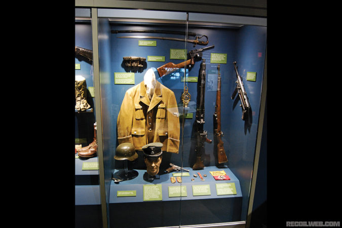 The weapons and gear of the enemy! This exhibit includes a Waffen SS visor cap to an officer, a German Model 35 steel helmet, K-98 Mauser rifle, MG-42 machine gun, MP-40 submachine gun, and C-96 “Broom handle” pistol.