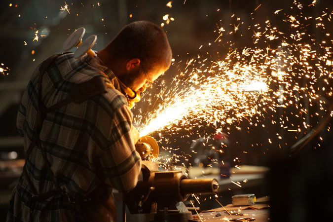 Grinding a blade with sparks flying everywhere.