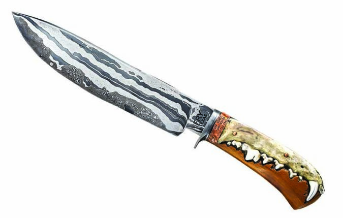 Coyote jaws, 1912 bois d’arc and a 1941 trap tag highlight the handle of the Trapper Bowie by BLADE Show Texas exhibitor Jason Fry. Blade damascus that includes among its forged components a vintage Newhouse trap spring is clad over a random damascus core. Overall length: 13 inches.